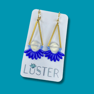 Brass statement earrings with opalite rounds and blue accents on branded card.