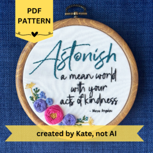 PDF pattern created by Kate, not AI. Astonish a mean world with your acts of kindness. Maya Angelou. Astonish hand embroidered in dark teal. Remaining quote and attribution hand embroidered in black. In the lower left side, a cluster of flowers with wreath with bright pink and purple roses, golden pointy flowers, and green stems with leaves and dark teal flower buds. Art is displayed in a medium dark grained wood-look embroidery hoop.