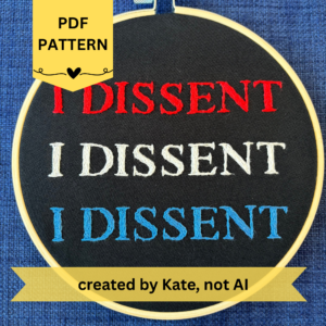 PDF Pattern. Created by Kate, not AI. Hoop reads, I dissent I dissent I dissent - Hand embroidered red, white, and blue "I dissent" in all capital letters. Fabric is black cotton. Embroidery is displayed in light wood embroidery hoop