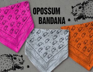 Sugar Camp Opossum bandanas in hot pink, soft gray, and burnt orange, sit over speckled gray background, and flanked by two cantankerous looking marsupials reaching for a juicy tick.