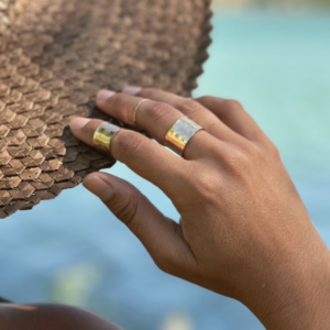 image of model wearing 14k gold filled cigar band rings which are thick rings with hammered texture